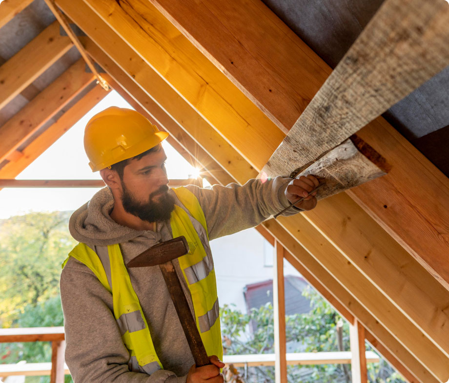 A roofer working on the timber frame of a roof